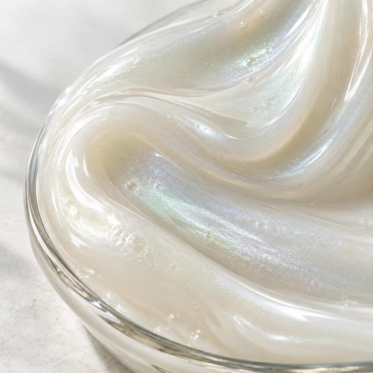 Opacifiers and pearlescents: a close-up of silky ivory pearlescent cosmetic texture.
